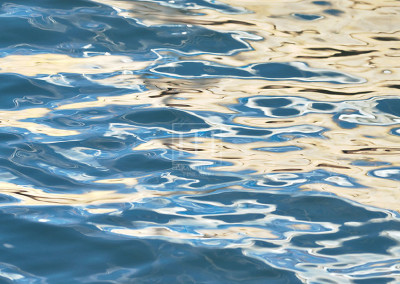 Drifting reflections on blue lake water like abstract photographic image