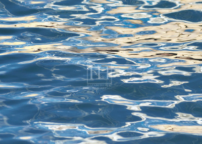 Drifting ripples reflections on blue lake water as abstract photographic image