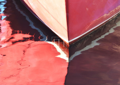 Interior Art painted red boat reflection on blue lake water as abstract fine art photography image by Canadian visual artist Elizabeth Hesp