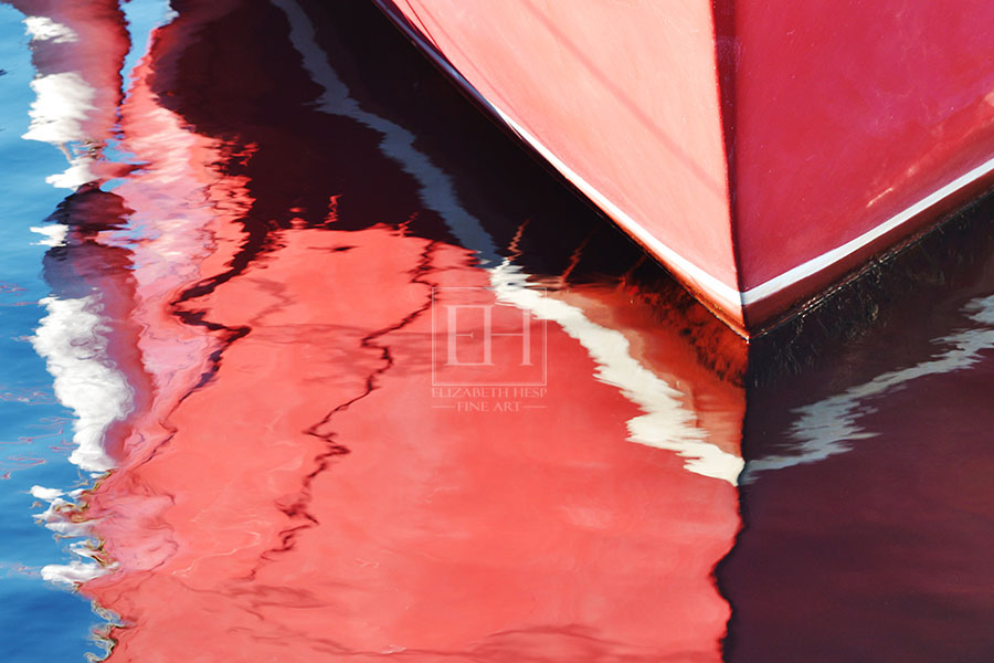 Reflection of red boat lines on blue lake water