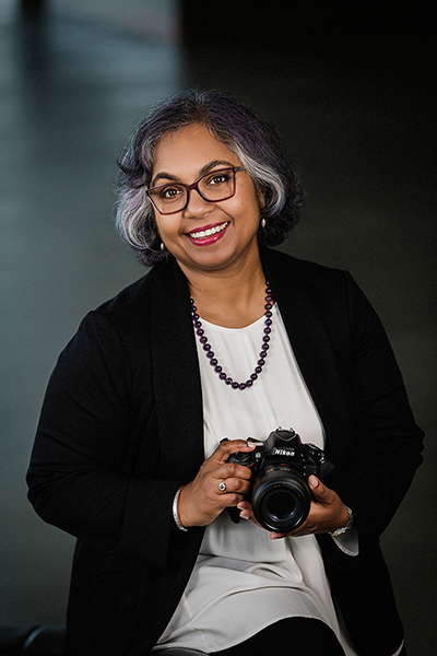 Elizabeth Hesp professional visual artist, fine art photographer holding camera and smiling